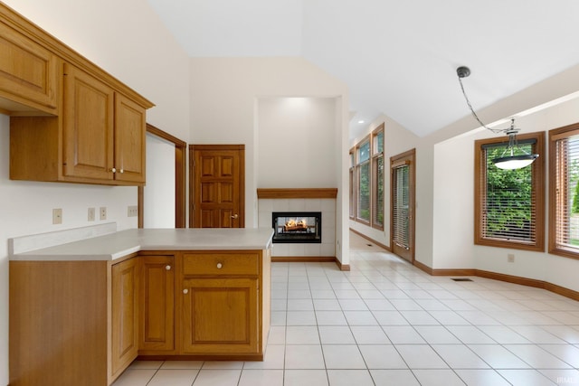 2519 Knightsbridge Dr, Fort Wayne, IN 46815 - kitchen featuring a peninsula, a fireplace, light countertops, light tile patterned flooring, and vaulted ceiling
