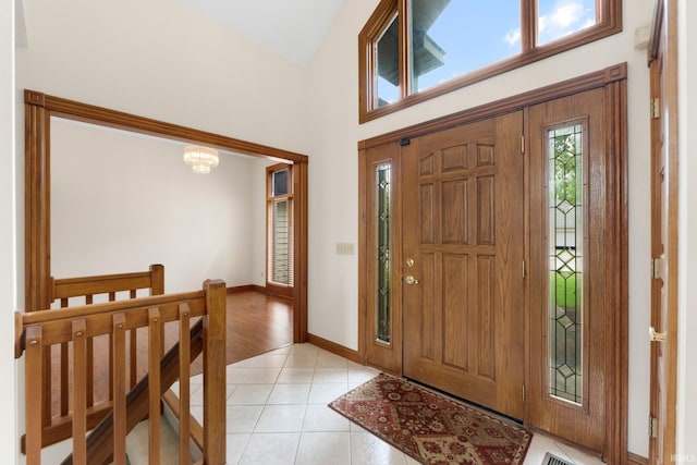 2519 Knightsbridge Dr, Fort Wayne, IN 46815 - entryway with light tile patterned floors, a chandelier, baseboards, and a high ceiling