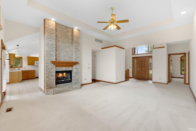 2519 Knightsbridge Dr, Fort Wayne, IN 46815 - unfurnished living room featuring a towering ceiling, ceiling fan, a brick fireplace, light carpet, and baseboards