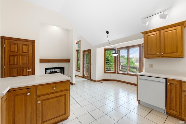 2519 Knightsbridge Dr, Fort Wayne, IN 46815 - kitchen featuring white dishwasher, light countertops, brown cabinetry, light tile patterned floors, and a tile fireplace