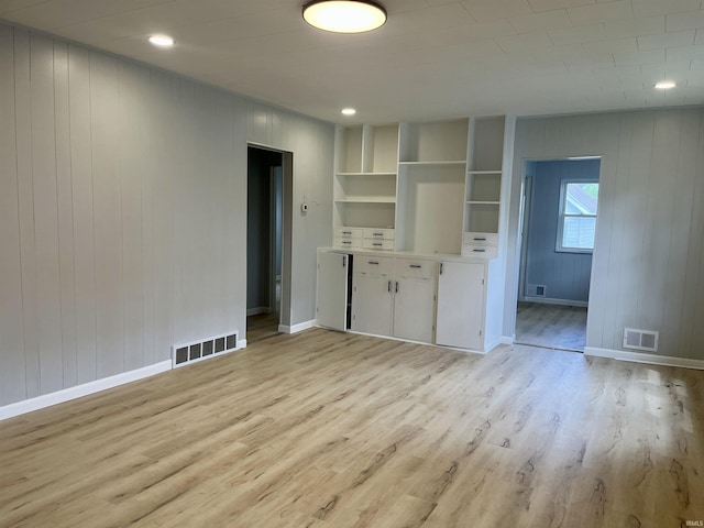 626 S 24th St, South Bend, IN 46615 - unfurnished living room with light wood-style flooring, baseboards, and wooden walls