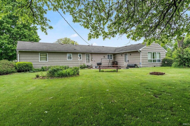 213 S Clark St, Auburn, IN 46706 - rear view of house featuring an outdoor fire pit and a lawn