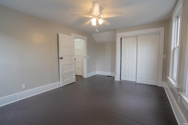 103 W US-24 Hwy, Idaville, IN 47950 - unfurnished bedroom featuring dark wood-style flooring, baseboards, a closet, ceiling fan, and multiple windows