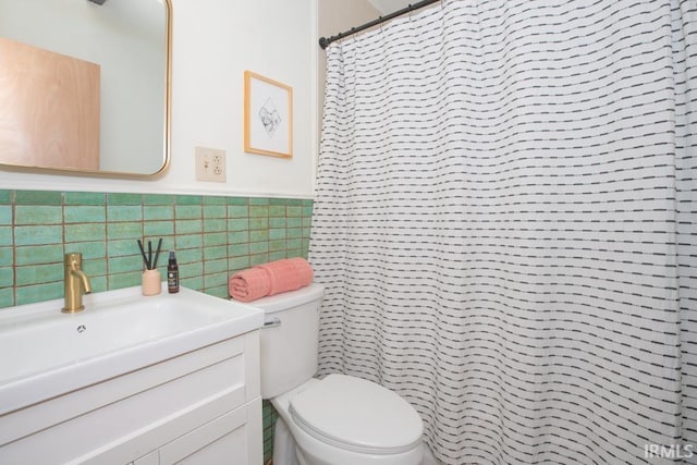 7300 E Blackford Ave, Evansville, IN 47715 - bathroom with tile walls, toilet, vanity, a shower with shower curtain, and wainscoting
