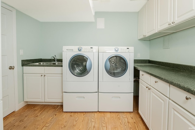 4691 E Inverness Woods Rd, Bloomington, IN 47401 - washroom featuring washing machine and clothes dryer, light wood finished floors, and cabinet space