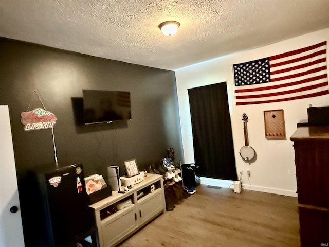 302 L St, Bedford, IN 47421 - bedroom featuring light wood-style floors, a textured ceiling, and baseboards