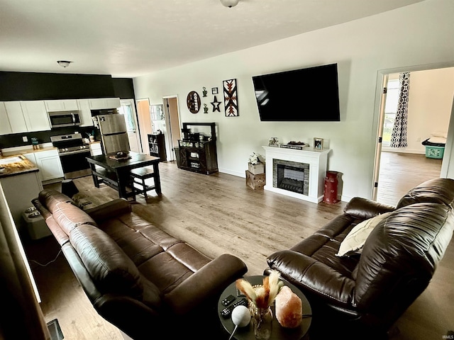 302 L St, Bedford, IN 47421 - living room featuring wood finished floors, a fireplace, and baseboards