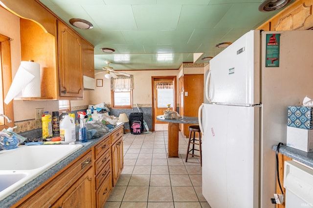 139 Elm St, Wabash, IN 46992 - kitchen featuring freestanding refrigerator, a sink, light tile patterned flooring, and brown cabinets