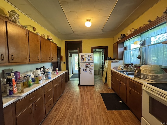 8595 W 1000 S Unit 35, Lafontaine, IN 46940 - kitchen featuring white appliances, a sink, light countertops, light wood-type flooring, and healthy amount of natural light