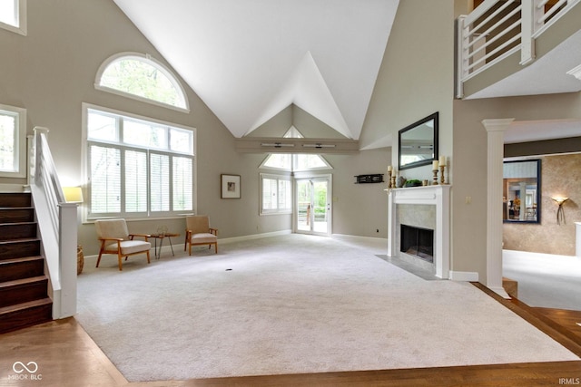 10919 Running Tide Ct, Indianapolis, IN 46236 - carpeted living area with high vaulted ceiling, stairway, a high end fireplace, and baseboards