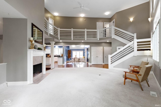10919 Running Tide Ct, Indianapolis, IN 46236 - carpeted living room with a towering ceiling, a ceiling fan, stairs, baseboards, and a high end fireplace