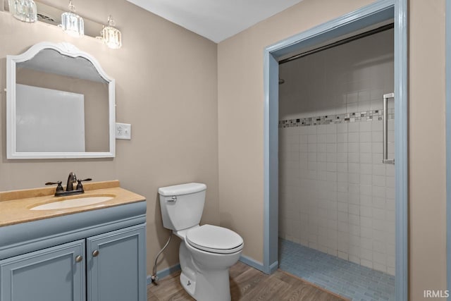 2545 N Bell St, Kokomo, IN 46901 - bathroom featuring tiled shower, toilet, vanity, wood finished floors, and baseboards