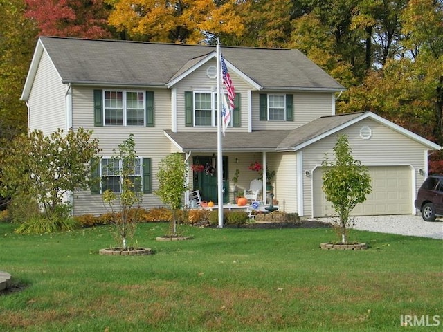 687 N Deer Lake Dr, Bloomfield, IN 47424 - view of front of home featuring covered porch, a front lawn, an attached garage, and driveway