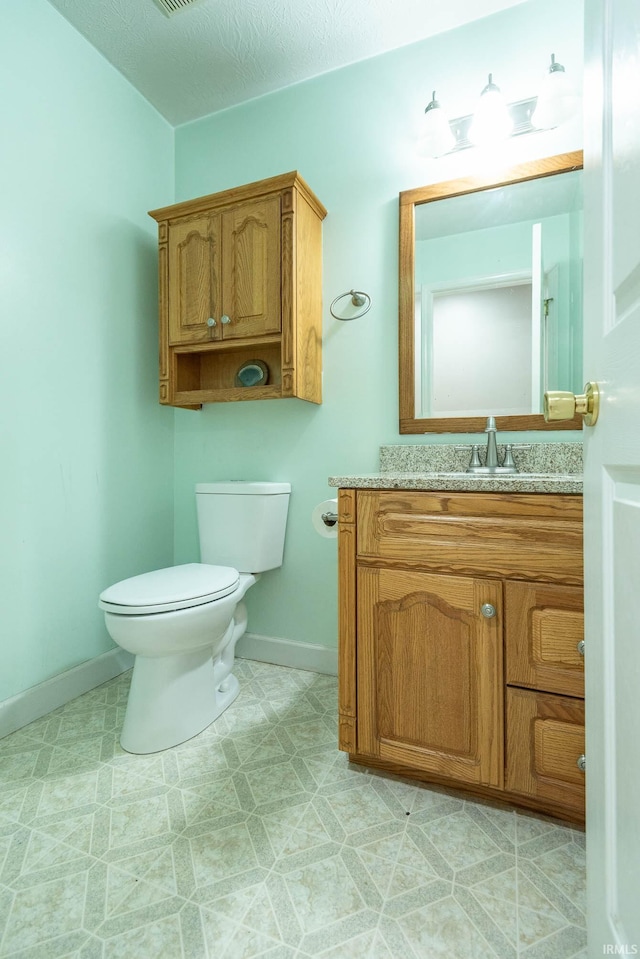 687 N Deer Lake Dr, Bloomfield, IN 47424 - half bathroom featuring toilet, baseboards, vanity, and tile patterned floors