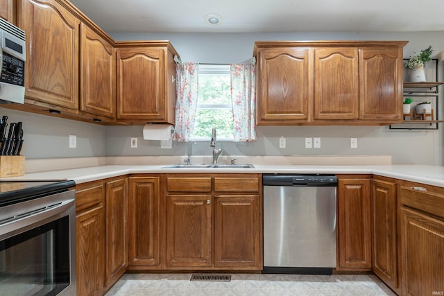687 N Deer Lake Dr, Bloomfield, IN 47424 - kitchen with appliances with stainless steel finishes, a sink, brown cabinets, and light countertops