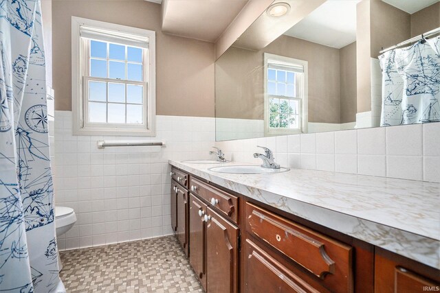 23337 Shorelane, Elkhart, IN 46514 - full bath featuring tile walls, double vanity, toilet, and wainscoting