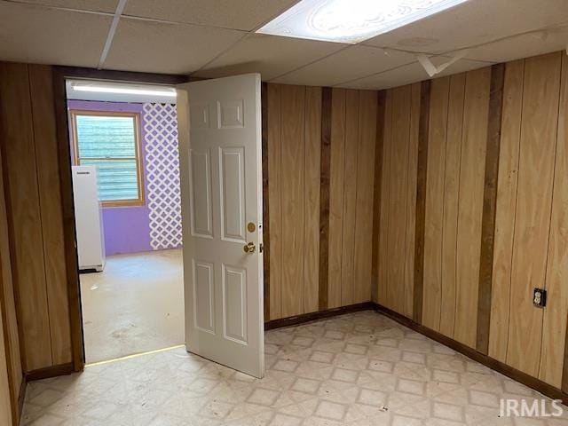 56862 Pomona St, Elkhart, IN 46516 - unfurnished room with wood walls, light flooring, and a paneled ceiling