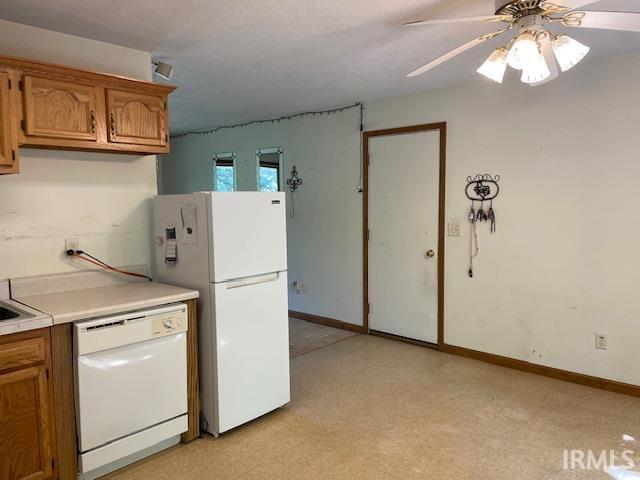 56862 Pomona St, Elkhart, IN 46516 - kitchen with white appliances, light countertops, brown cabinetry, and light floors