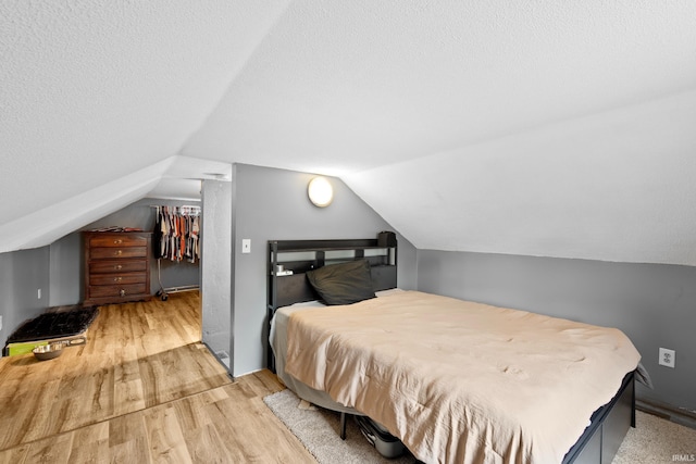 753 W Centennial St, Nappanee, IN 46550 - bedroom with wood finished floors, vaulted ceiling, a walk in closet, a closet, and a textured ceiling