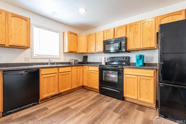 7203 W Capstone Cir, Bloomington, IN 47404 - kitchen featuring black appliances, a sink, dark countertops, light wood-style floors, and recessed lighting