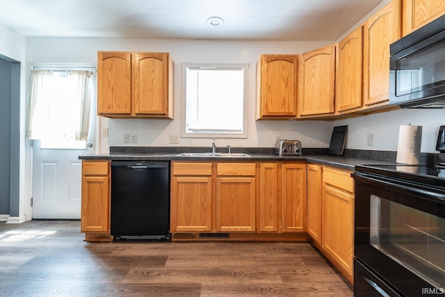 7203 W Capstone Cir, Bloomington, IN 47404 - kitchen with black appliances, a sink, dark countertops, and dark wood-style flooring