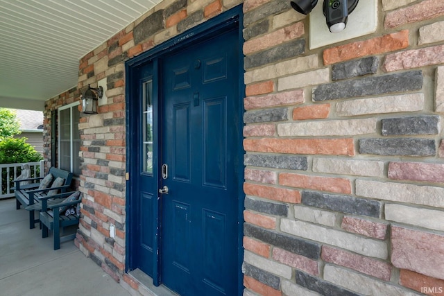 7203 W Capstone Cir, Bloomington, IN 47404 - property entrance featuring a porch and brick siding