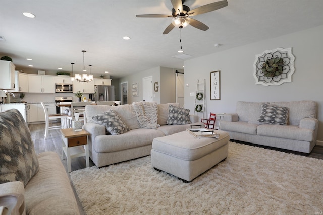606 W Elm St, Haubstadt, IN 47639 - living room featuring wood finished floors, recessed lighting, a ceiling fan, and a chandelier