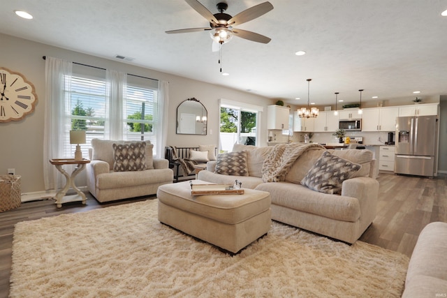 606 W Elm St, Haubstadt, IN 47639 - living room with wood finished floors, a chandelier, recessed lighting, and ceiling fan
