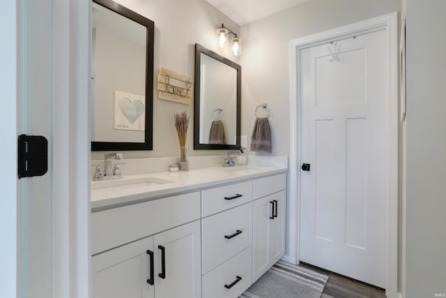 606 W Elm St, Haubstadt, IN 47639 - bathroom featuring double vanity and wood finished floors