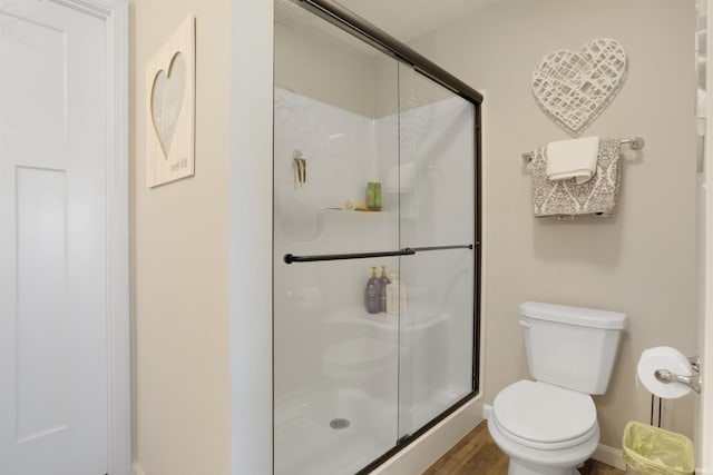 606 W Elm St, Haubstadt, IN 47639 - bathroom featuring toilet, a stall shower, baseboards, and wood finished floors
