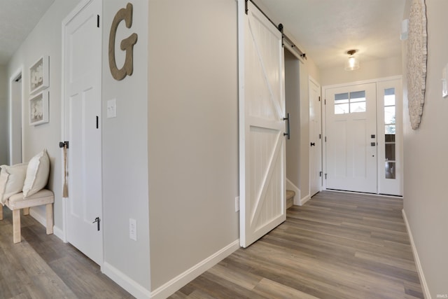 606 W Elm St, Haubstadt, IN 47639 - entryway featuring a barn door, baseboards, and wood finished floors