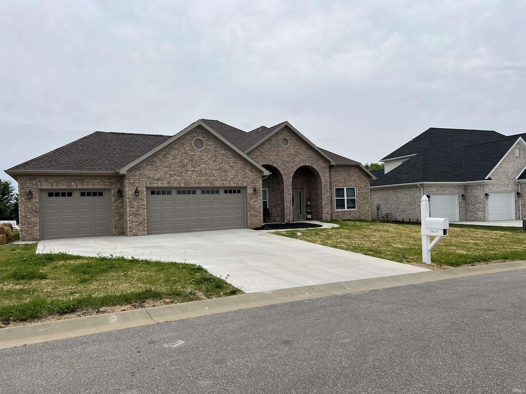 7815 Jt Ct, Evansville, IN 47715 - french country home with brick siding, a garage, a front yard, and concrete driveway