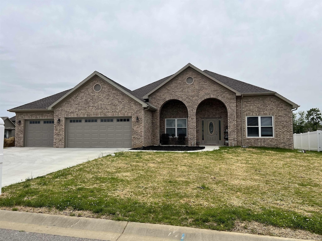 7815 Jt Ct, Evansville, IN 47715 - view of front of home with brick siding, a garage, driveway, and a shingled roof