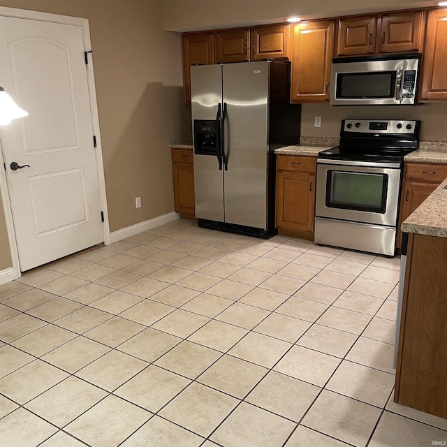 1841 S Patriot Dr, Yorktown, IN 47396 - kitchen with appliances with stainless steel finishes, light tile patterned floors, light countertops, baseboards, and brown cabinets