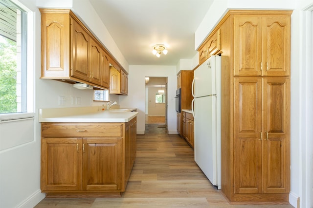 16128 Chandler Blvd, Mishawaka, IN 46544 - kitchen with freestanding refrigerator, black oven, light wood-style flooring, and healthy amount of natural light