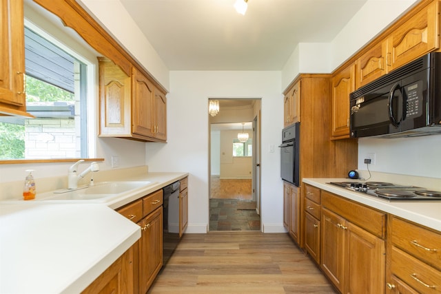16128 Chandler Blvd, Mishawaka, IN 46544 - kitchen featuring black appliances, a sink, light countertops, light wood-type flooring, and brown cabinetry
