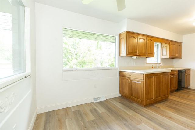 16128 Chandler Blvd, Mishawaka, IN 46544 - kitchen with light countertops, dishwasher, light wood-type flooring, brown cabinets, and ceiling fan