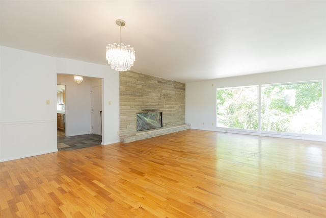 16128 Chandler Blvd, Mishawaka, IN 46544 - unfurnished living room with a chandelier, light wood finished floors, and a fireplace
