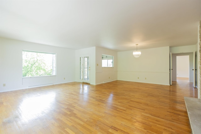 16128 Chandler Blvd, Mishawaka, IN 46544 - unfurnished living room with baseboard heating, healthy amount of natural light, a chandelier, and light wood finished floors