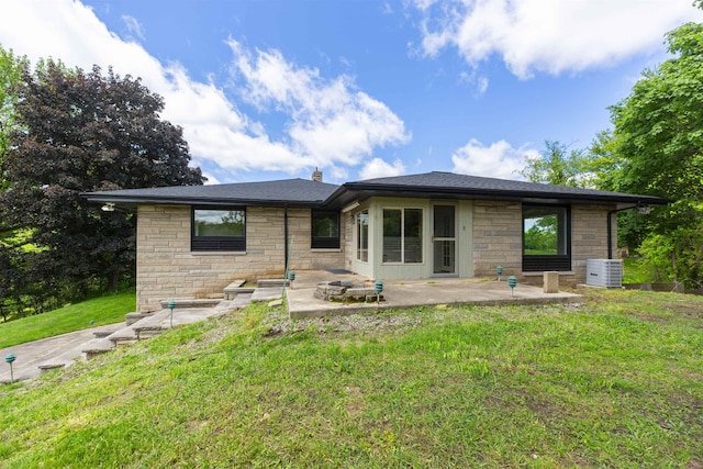 16128 Chandler Blvd, Mishawaka, IN 46544 - back of house with stone siding, a patio area, a lawn, central AC unit, and a chimney