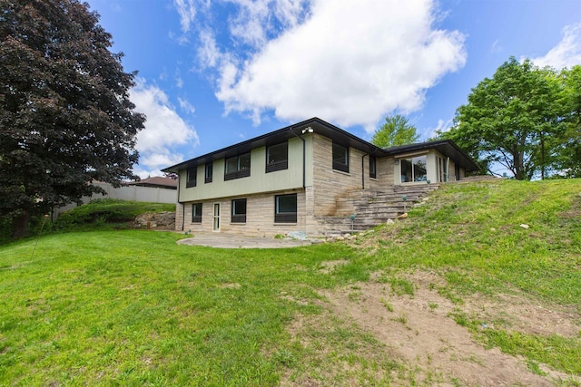 16128 Chandler Blvd, Mishawaka, IN 46544 - rear view of property featuring stone siding, a patio, and a lawn