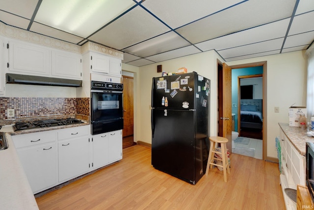 4893 Woodway Dr, Fort Wayne, IN 46835 - kitchen featuring black appliances, a warming drawer, a paneled ceiling, white cabinets, and light wood-style floors