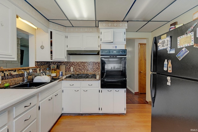 4893 Woodway Dr, Fort Wayne, IN 46835 - kitchen with black appliances, a warming drawer, white cabinets, a sink, and light wood finished floors