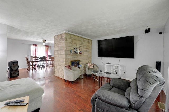 4893 Woodway Dr, Fort Wayne, IN 46835 - living room with wood finished floors, a stone fireplace, baseboards, and a textured ceiling