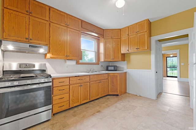 3550 Sandpoint Rd, Fort Wayne, IN 46809 - kitchen featuring gas stove, under cabinet range hood, light countertops, plenty of natural light, and wainscoting