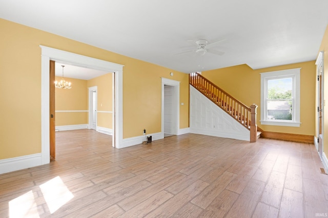 3550 Sandpoint Rd, Fort Wayne, IN 46809 - unfurnished living room featuring stairway, a chandelier, ceiling fan, light wood finished floors, and baseboards