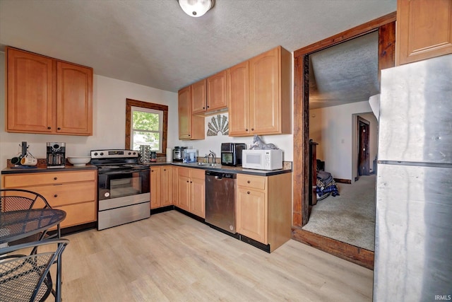 408 S Sale St, Ellettsville, IN 47429 - kitchen with stainless steel appliances, dark countertops, and light wood-style flooring