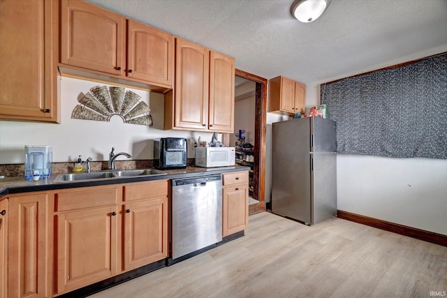 408 S Sale St, Ellettsville, IN 47429 - kitchen with stainless steel appliances, a sink, light wood-type flooring, dark countertops, and a textured ceiling