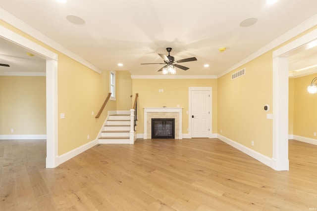 324 W Mishawaka Ave, Mishawaka, IN 46545 - unfurnished living room with ceiling fan, crown molding, light wood-type flooring, a glass covered fireplace, and stairs