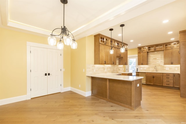 324 W Mishawaka Ave, Mishawaka, IN 46545 - kitchen with brown cabinets, a peninsula, light wood-style floors, backsplash, and recessed lighting